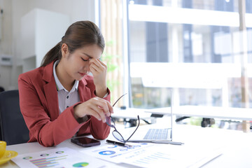 Stressed businesswoman overwhelmed with work and deadlines at the office.