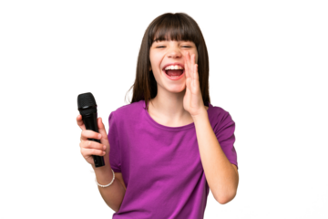 Little singer girl picking up a microphone over isolated background shouting with mouth wide open