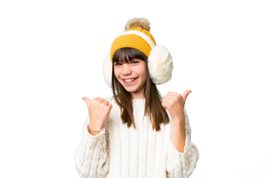 Little caucasian girl wearing winter muffs over isolated background with thumbs up gesture and smiling
