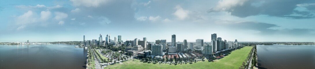 Drone shot of Perth cityscape from Swan River showing skyscrapers under bright sunlight