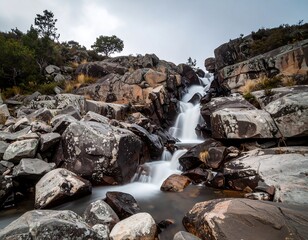 Cascading waterfall flowing over dark rocks, long exposure shot