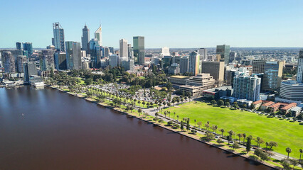 Fototapeta premium Drone shot of Perth cityscape from Swan River showing skyscrapers under bright sunlight