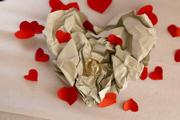 Gold Wedding Rings on Light Paper Background &ndash; Paper Wedding Anniversary. Minimal still life of gold wedding rings on light paper surface with soft shadows and airy composition, symbolizing tenderness