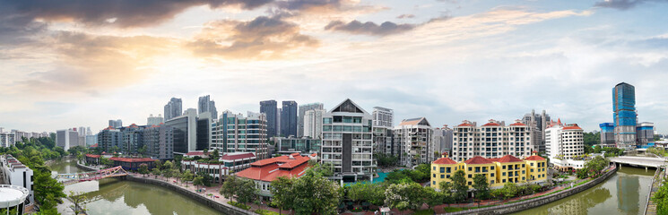 Urban cityscape of Singapore riverfront skyscrapers illuminated by warm sunset light