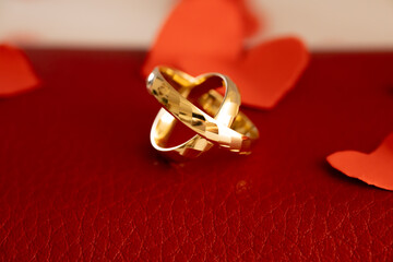 Gold Wedding Rings on Dark Leather Texture &ndash; Leather Anniversary. Dramatic still life of gold wedding rings on dark leather surface with rich texture and contrast lighting, representing strength