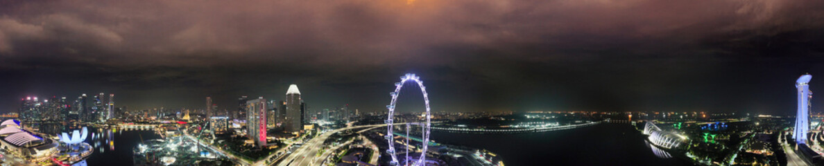 Night panoramic aerial view of Singapore Marina Bay skyline with city lights and reflections
