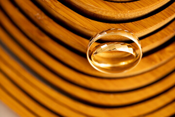 Gold Wedding Rings on Wooden Background &ndash; Wooden Wedding Anniversary. Close-up of gold wedding rings placed on a warm wooden surface with natural texture and soft directional light, symbolizing 