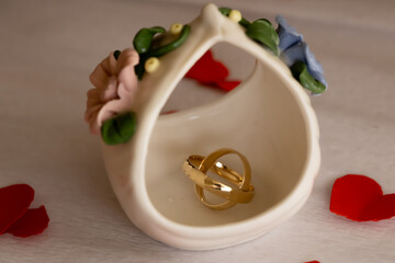 Minimal Gold Wedding Rings on Faience Background. Clean and minimal composition of gold wedding rings on faience surface symbolizing harmony and lasting relationship.
