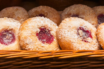 Sweet freshly baked pie with sugar powder and fruit jam in a wicker basket, closeup. Homemade organic French baking. Pastry background.