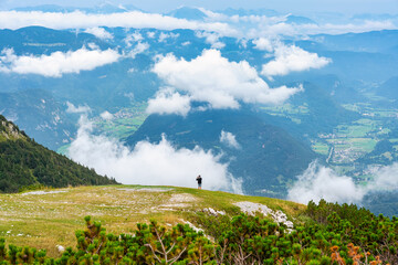 Tourist taking photos in the stunning scenery of the Julian Alps at Vogel Station, Slovenia.