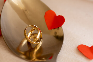 Gold Wedding Rings on Steel Spoon with Soft Light