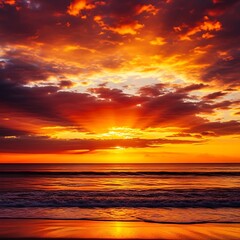 Obraz premium Dramatic fiery sunset over the ocean with reflective water and clouds