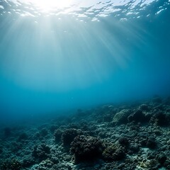 Sunlight streams through clear blue ocean water onto a vibrant coral reef below