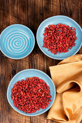 Dried goji berries in bowl on table.