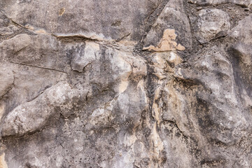 a fragment of the laying of a stone wall made of large rough gray stone. stone background. natural texture. a model, a sample of a stone wall.