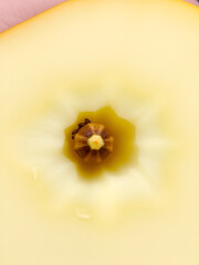 A single fresh slice of a yellow apple showing its pale flesh core and one brown seed.