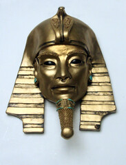 Ancient pharaoh mask sculpture with golden metallic finish and turquoise details. Alien-like eyes evoke mystery, blending Egyptian heritage with otherworldly symbolism.Frontal face on white background