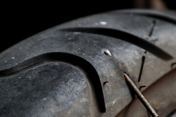 Close up A motorbike tubeless tire that is stuck in iron nails, this can cause a leak and must be repaired immediately. 