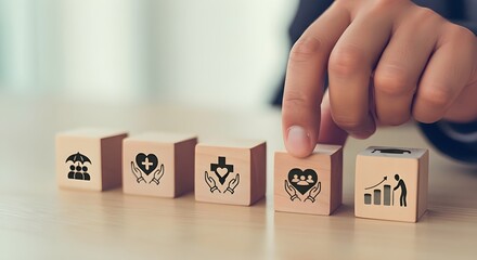 Naklejka premium Wooden blocks with healthcare and health insurance icons arranged by hand on desk