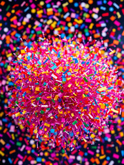 Burst of Color: A vibrant explosion of confetti, meticulously arranged in a photorealistic style. The scene is awash with diverse hues, presenting a spectacle of joy and festivity.