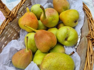 Fresh ripe pears in wicker basket with paper lining