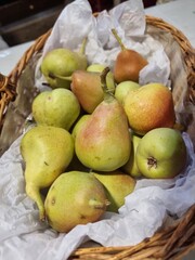 Fresh ripe pears in wicker basket with paper lining