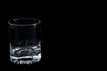 Empty glass on black background – minimalist studio setup