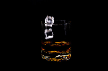 Whiskey with Ice Cubes Falling