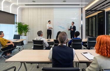 Business presentation in modern conference room showcasing data analysis and strategic planning with engaged audience participation