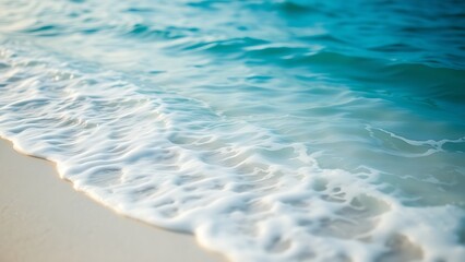 Calm blue ocean waves gently rolling onto a white sandy beach, evoking tropical serenity.