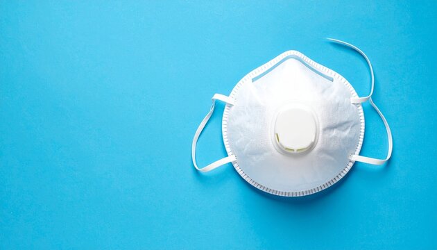 White N95 respirator mask&mdash;central exhalation valve, dual elastic straps, placed on solid light blue background, evokes themes of protection, healthcare, and respiratory safety.