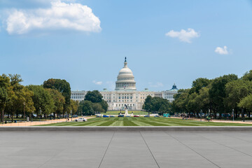 United States Capitol building in Washington D.C. on a bright summer day with a large paved...