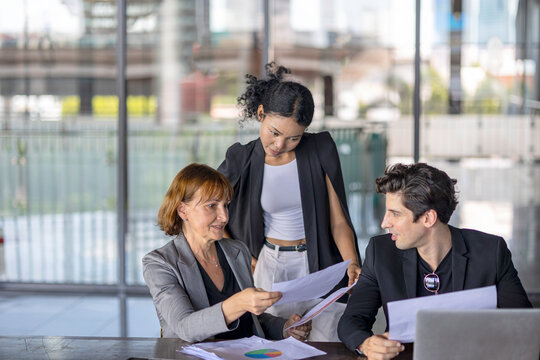Group of managers or business workers share heir happiness after achieving project target. A moment of team's collective efforts in business workplace shared by members from different generations