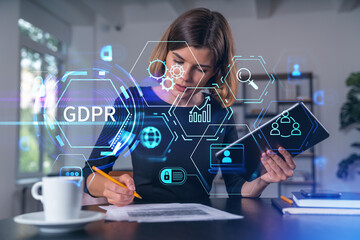 Woman analyzing GDPR compliance data with digital interface graphics in office environment representing data protection concept background.