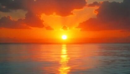 Obraz premium Stunning sunset over calm ocean waters with vibrant orange and yellow hues, reflecting serene beauty