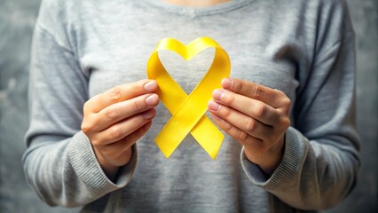 yellow ribbon in hands sick person suffering from cancer make heart symbol, world cancer day, healthcare and medicine backdrop, suicide prevention, children health care.