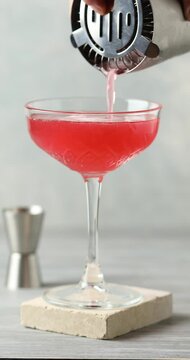 Alcoholic cocktail clover club with raspberries in a cocktail glass on the table.
