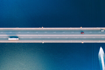 Aerial drone view river or sea water bridge with moving traffic  of boat and cars and trucks. Road...
