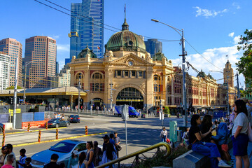 Flinders Street Station in Melbourne, Australia, with busy street life and modern skyscrapers in the background, showcasing the city’s historic and urban contrast.