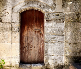 Wooden door in the stone wall, part of the outdoor architecture of Suleymaniye Mosque, in Istanbul, Turkey