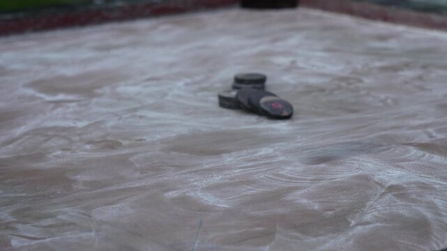 Boys are playing carrom board with powder and carrom pieces 