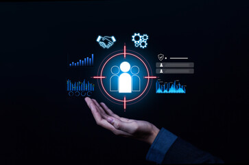 Business hand holding digital target audience icon with data charts, analytics, and strategy symbols, representing customer focus, marketing, segmentation, business growth, and audience engagement.