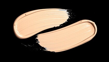 Two creamy swatches of light beige liquid foundation or concealer smeared on a solid black background.