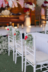 Wedding ceremony chairs decorated with flowers and soft lighting