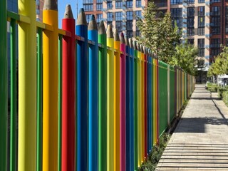 Close up multi colored fence in the form of large colored pencils. School concept. Copy space 