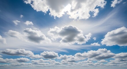 Bright sun shines through scattered cumulus clouds in a vast blue sky, creating a peaceful, wide-open vista