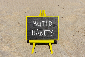 Build habits symbol. Concept word Build habits on beautiful black blackboard. Beautiful sand beach background. Black blackboard. Business build habits concept. Copy space.
