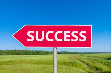 Success symbol. Concept word Success on beautiful red road sign. Beautiful blue sky green grass and forest peaceful nature background. Business success concept. Copy space.