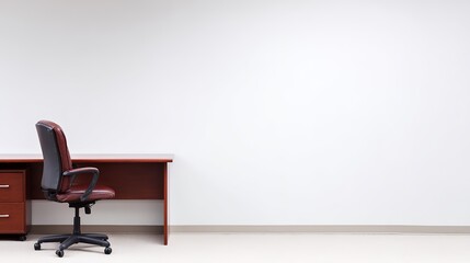 organized. A clean and simple office corner featuring a wooden desk and chair under soft natural light. real-estate listings.