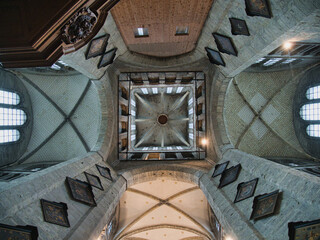 Vaulted Ceilings of Ghent Cathedral - A low-angle, interior view of the complex gothic vaulted ceilings and arches of a historic cathedral in Ghent.
